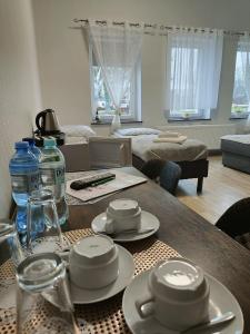 RunowoPałac pod Bocianim Gniazdem的客厅配有带盘子和水瓶的桌子