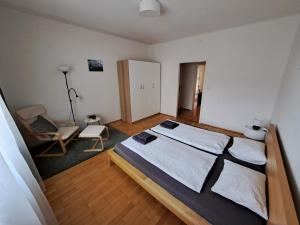 格拉茨Flataid Apartment Elisabethinergasse的一间卧室,卧室内配有一张床和一把椅子