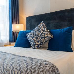 都柏林埃克尔斯联排别墅 的一间卧室配有一张带蓝色枕头的床