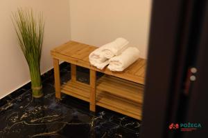 波热加Apartment Eden的浴室内一张木桌旁的两条毛巾