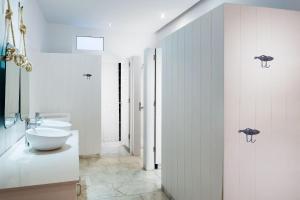 波多黎各大加那利滨海套房酒店的白色的浴室设有卫生间和水槽。
