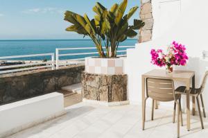 波多黎各大加那利岛海湾景码头公寓 - 仅限成人入住的俯瞰大海的阳台配有桌椅