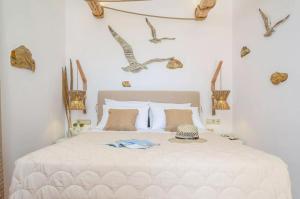 布拉卡Glaronissi Beach的卧室配有白色的床,墙上有鸟儿