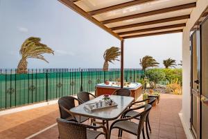卡门港Villa Kanak的一个带桌椅的庭院和大海