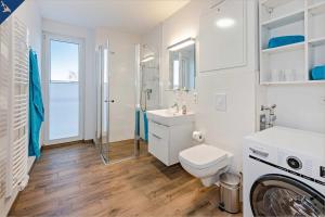 ZirchowHaffblick 1的浴室配有卫生间、盥洗盆和洗衣机。