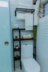 基加利Neza Haven Kigali的一间带卫生间和架子毛巾的浴室