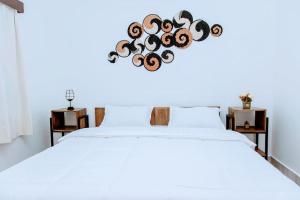 基加利Neza Haven Kigali的一间卧室配有一张白色的床,床心由原木制成