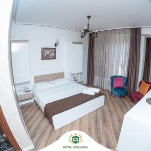 GjakoveHotel Apollonia的酒店客房,配有床和镜子