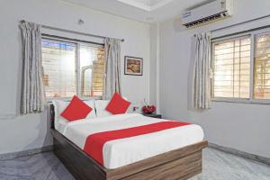 LohogaonOYO Flagship 87488 Hotel Green Breeze的一间卧室配有一张带红色枕头的大床