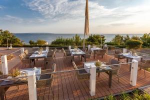 奥斯赛拜-塞林伯恩斯坦酒店的一个带桌椅的庭院,以及背景海洋