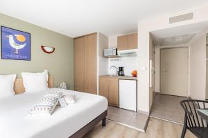 马赛Appart'City Classic Marseille Euromed的酒店客房带一张床和一个厨房