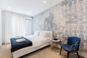 圣朱利安斯The G Hotel by JL的一间卧室配有一张床和一张蓝色椅子