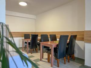 里马夫斯卡索博塔AM Motel的一间会议室,配有木桌和黑椅子