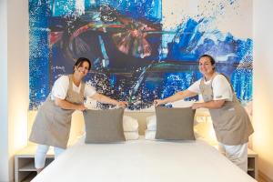 利尼亚诺萨比亚多罗Art Hotel Principe的两个女人站在床边