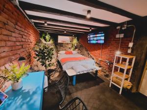 瓦尔帕莱索Maki Hostels & Suites Valparaiso的一间卧室设有一张床和砖墙
