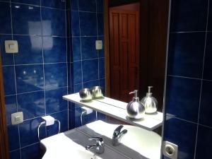 坎皮卡福特GLORIA apartament NEAR THE BEACH的蓝色瓷砖浴室设有水槽和镜子