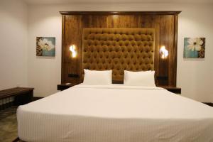 希克杜沃Hotel Refresh Blue的卧室配有一张白色大床和木制床头板