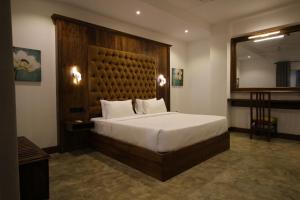 希克杜沃Hotel Refresh Blue的一间卧室配有一张大床和木制床头板