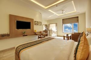 新德里Airport Hotel Claytone的酒店客房设有一张大床和一台电视。