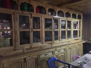 PhakdingTribeni Lodge Restaurant And Bar的木柜,带玻璃门,配有桌椅