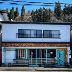 Mamiharaomusubi guest house (JAPANESE　STYLE）的蓝色和白色的建筑,设有阳台
