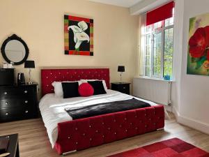 林顿Exmoor Manor Guest House的一间卧室配有一张大床和红色床头板