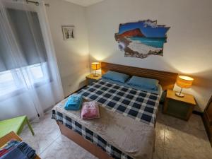 AbadesLa Casa del Sol, Abades的卧室配有一张床,墙上挂有绘画作品