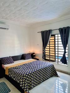 科托努Charly Agla-Piscine的一间卧室设有一张床和一个窗口