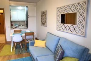 丰沙尔Monumental Apartment的一间带蓝色沙发的客厅和一间厨房