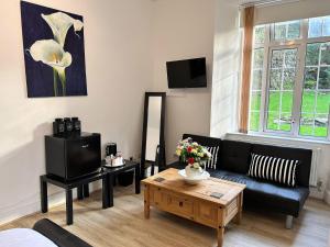 林顿Exmoor Manor Guest House的客厅配有黑色沙发和咖啡桌
