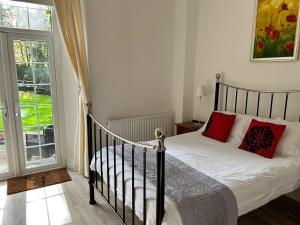 林顿Exmoor Manor Guest House的一间卧室配有一张带红色枕头的床和一扇窗户