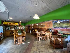 埃博森Ankatu Hostel的餐厅拥有绿色的墙壁和木桌及椅子