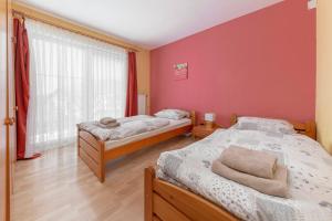 Spodnje GorjeApartments Žnidar的红色墙壁客房的两张床