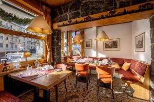 格林德尔瓦尔德Hotel Kreuz&Post**** Grindelwald的餐厅设有木桌、椅子和窗户