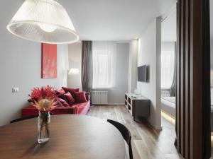 敖德萨Il Decameron Luxury Design Hotel的客厅配有桌子和红色沙发