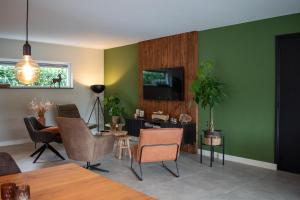 Loon op ZandHotel B&B Buiten Loon的客厅设有绿色的墙壁和桌椅