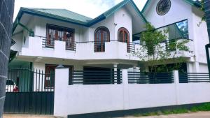 努沃勒埃利耶Nuwara Eliya Holiday Home的白色房屋,设有围栏