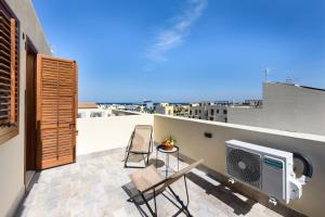 圣维托罗卡波I Tre Golfi - Appartamenti a 800 mt dal centro的阳台配有两把椅子和屋顶电视。