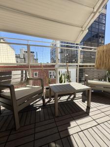 布宜诺斯艾利斯永宏格兰德酒店的阳台设有带长凳和桌子的庭院。