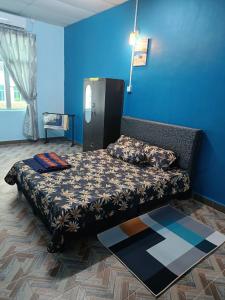 金宝SR KAMPAR HOMESTAY的蓝色墙壁间的一张床位