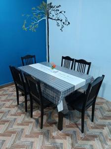金宝SR KAMPAR HOMESTAY的餐桌,带四把椅子和一棵树