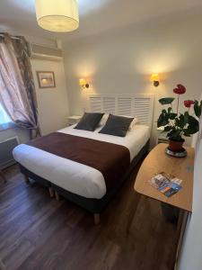 奥朗日Le Clos d'Orange, Hotel & ville de Provence的一间卧室配有一张大床和一张桌子