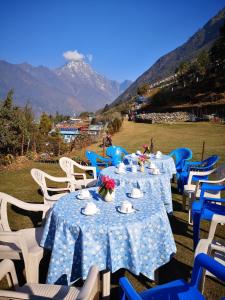 LuklaLukla Himalaya Lodge的一组蓝色和白色的桌子,上面有鲜花