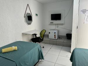 累西腓Casa Recife Pousada的一间医院间,配有桌子和电视