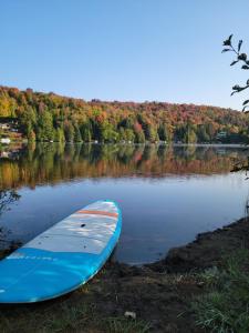 Saint Adolphe D'HowardRetraite au lac avec SPA privé et embarcations的蓝色的皮艇坐在湖边