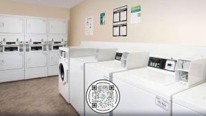 阿诺德WoodSpring Suites St Louis Arnold的洗衣房配有白色洗衣机和橱柜