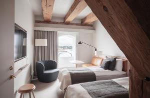哥本哈根哥本哈根埃德莫瑞酒店的一间卧室配有一张床、一张沙发和一把椅子