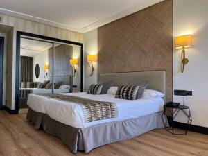 桑坦德港湾酒店的一间卧室设有一张大床和一个大镜子