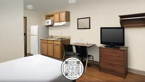 林垦WoodSpring Suites Lincoln Northeast I-80的厨房配有电视和桌椅