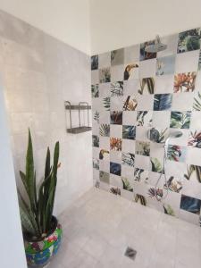 NindiríHotel Amigo Nicaragua的浴室设有盆栽和瓷砖墙